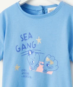T-shirt bébé fille en coton bio bleu avec motifs coquillages et étoiles pailletées